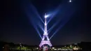 Pertunjukan cahaya menerangi Menara Eiffel saat perayaan ulang tahunnya ke-130 tahun di Paris, Rabu (15/5/2019). Paris memberikan ucapan ulang tahun kepada Menara Eiffel dengan pertunjukan laser yang rumit menelusuri kembali sejarah 130 tahun monumen itu. (AP/Christophe Ena)