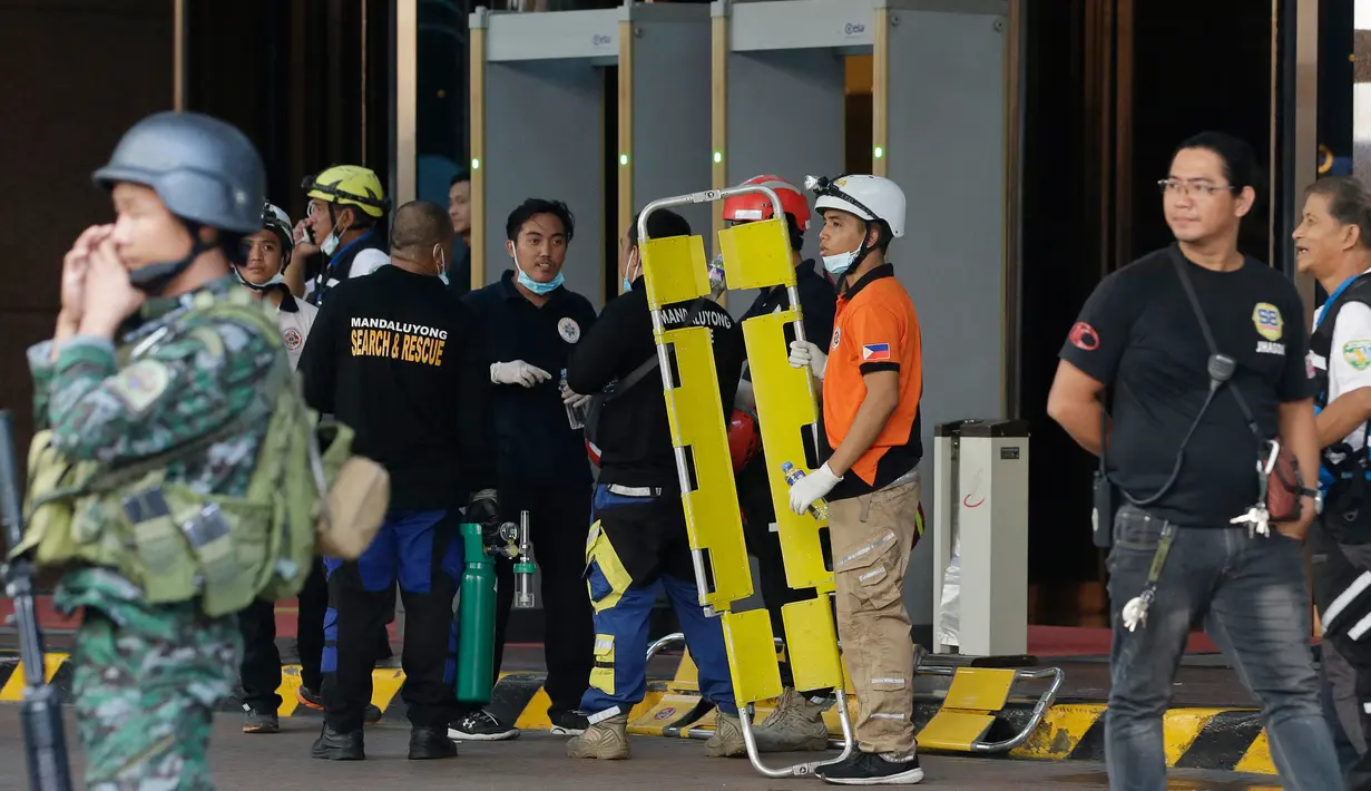 Petugas penyelamat bersiaga di luar Resorts World Manila, usai penembakan brutal, Jumat (2/6). Seorang pria bersenjata melakukan serangan dengan menembaki ke arah pengunjung dan meja kasino yang ada di dalam hotel. (AP Photo/Aaron Favila)