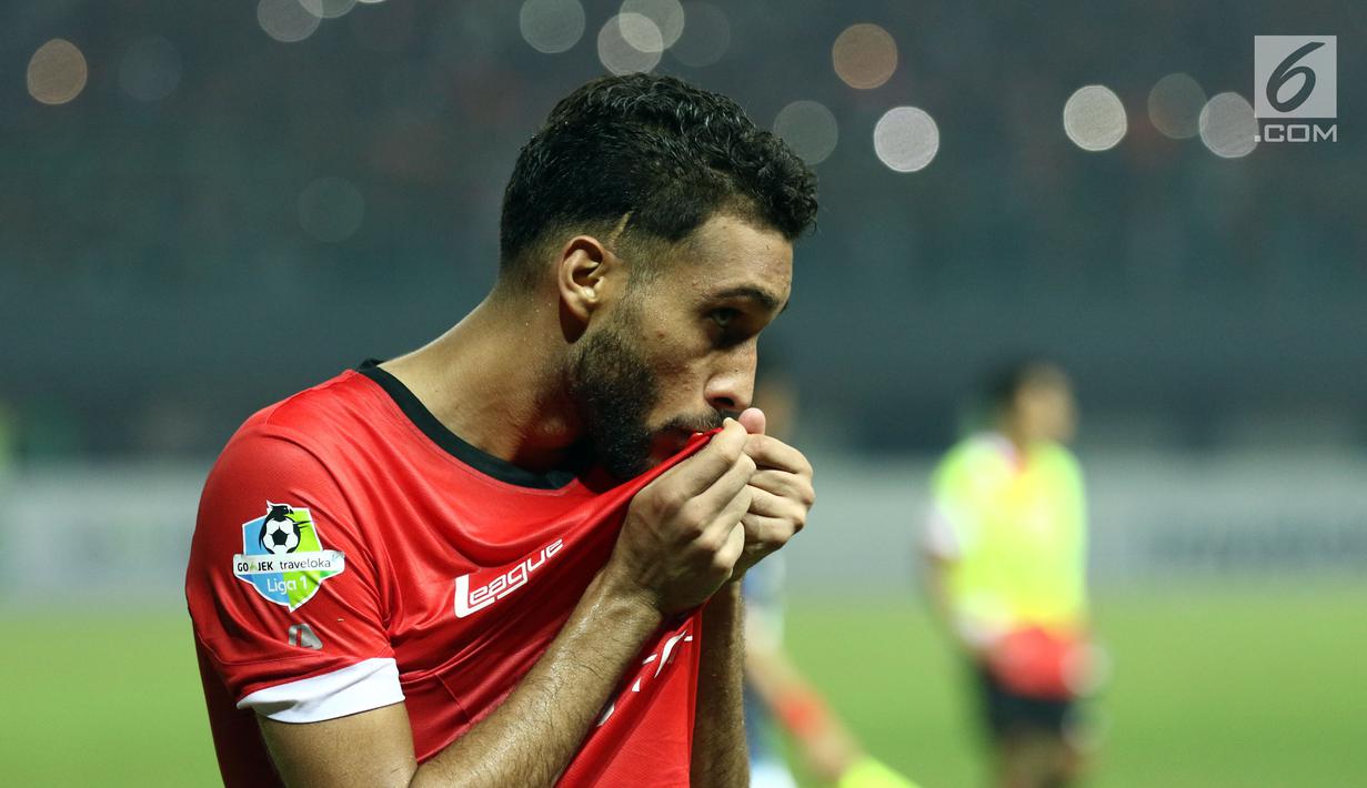 Bek Persija, Willian Pachecho mencium logo tim usai memenangi laga melawan Arema FC dilanjutan Liga 1 Indonesia di Stadion Patriot Candrabhaga, Bekasi, Jumat (2/6). Persija unggul 2-0 atas Arema FC. (Liputan6.com/Helmi Fithriansyah)