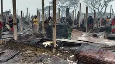 Pengungsi Rohingya berjalan di sisa-sisa yang hangus setelah kebakaran terjadi di Kamp Nayapara di distrik Cox's Bazar, Bangladesh, Kamis (14/1/2021). Ratusan rumah yang menjadi tempat tinggal ribuan pengungsi Rohingya hancur akibat dilalap api. (AP Photo/Mohammed Faisal)