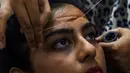 Seorang wanita Pakistan membersihkan rambut di wajah di salon kecantikan menjelang  Hari Raya Idul Fitri di Karachi (3/6/2019). Umat Muslim di seluruh dunia sedang bersiap untuk merayakan Hari Raya Idul Fitri, yang menandai akhir bulan puasa Ramadan. (AFP Photo/Asif Hassan)