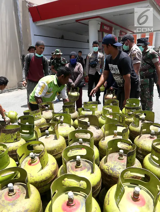 Petugas menyalurkan tabung gas elpiji 3 kg saat operasi pasar elpiji di SPBU Ki Hajar Dewantara di Palu, Sulawesi Tengah, Senin (8/10). Pertamina melakukan operasi pasar elpiji pascagempa dan tsunami Palu di 16 titik. (Liputan6.com/Fery Pradolo)