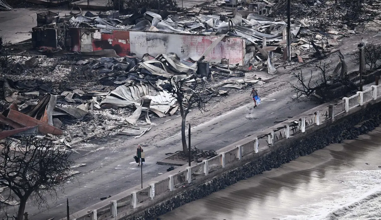 Gambar udara yang diambil pada tanggal 10 Agustus 2023 menunjukkan seseorang berjalan di Front Street melewati bangunan-bangunan yang hancur terbakar habis di Lahaina setelah kebakaran hutan di Maui barat, Hawaii. (Patrick T. Fallon/AFP)