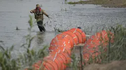 Pemasangan tersebut sebagai upaya untuk mencegah para migran menyeberangi sungai yang berbahaya itu untuk masuk ke Amerika Serikat secara ilegal. (AP Photo/Eric Gay)