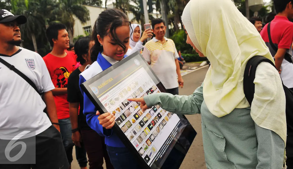 Duta cilik anti narkoba BNNP memberikan penjelasan jenis-jenis narkoba di CFD, Jakarta, Minggu (5/2). Soasialisi tersebut dilakukan untuk memberikan pengetahuan kepada masyarakat jenis narkoba dan bahaya narkoba. (Liputan6.com/Angga Yuniar)