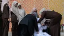 Petugas Kejaksaan Negeri Banda Aceh bersama tim medis mengangkat terpidana yang jatuh pingsan seusai menjalani hukuman cambuk di Taman Bustanussalatin, Banda Aceh, Aceh, Kamis (2/7/2026). (AP Photo/Reza Saifullah)