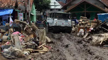 PMI mengerahkan kendaraan Hagglund di Kampung Bojong Sudika, Cimacan, Garut, Jumat (23/9). Kendaraan hagglund guna mempermudah mobilisasi sukarelawan dan proses evakuasi di tengah kawasan yang penuh lumpur akibat banjir bandang. (Liputan6.com/Johan Tallo)