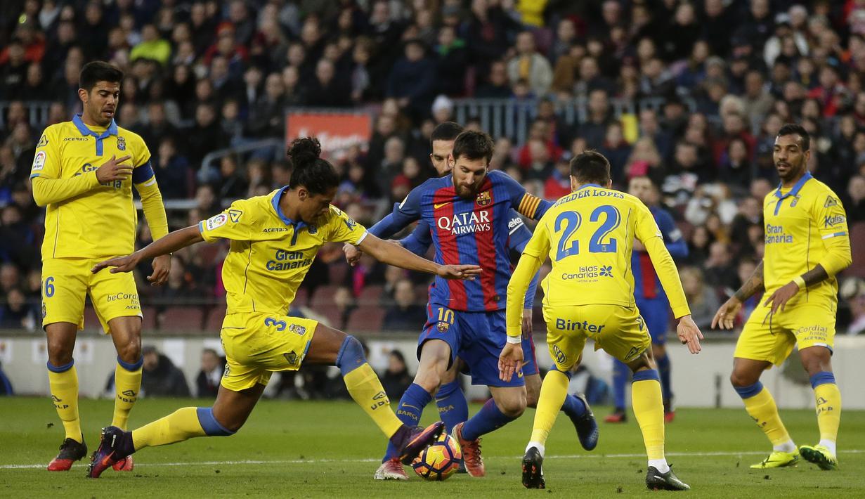 Aksi Pemain FC Barcelona, Lionel Messi saat dikepung para pemain Las Palmas pada laga La Liga di Camp Nou, Barcelona (14/1/2017). Barcelona menang 5-0. (AP/Manu Fernandez)