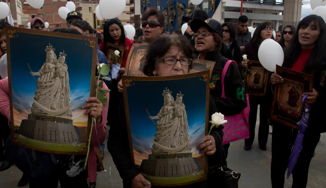 Sejumlah wanita membawa poster yang menyimbolkan gambar Our Lady of Socavon saat mengikuti prosesi untuk menghormati santo pelindung mereka, di Oruro, Bolivia (1/3). Mereka mendadak melakukan prosesi ini. (AP Photo/Juan Karita)