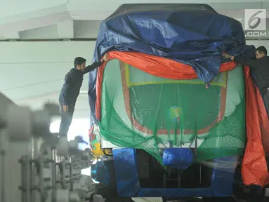 Pekerja membuka selubung skytrain atau automated people mover system (APMS) yang baru dipasang di Terminal 3 Bandara Soekarno Hatta, Tangerang, Selasa (30/5). Rencananya Kereta tanpa awak ini akan di uji pertengahan Juni . (Liputan6.com/Helmi Afandi)