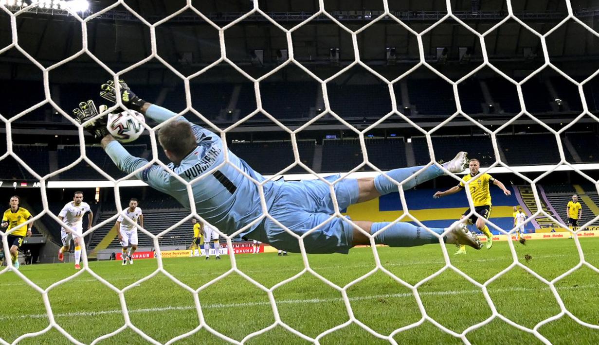 Penjaga gawang Armenia David Yurchenko menyelamatkan tembakan saat melawan Swedia pada pertandingan persahabatan jelang Euro 2020 di Solna, Swedia, Sabtu (5/6/2021). Swedia menang 3-1. (Janerik HENRIKSSON/TT News Agency/AFP)