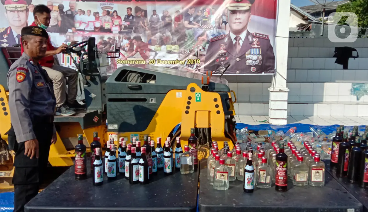 Petugas dengan alat berat menghancurkan botol minuman keras (miras) saat pemusnahan Miras dan barang bukti narkotika di Mapolrestabes Semarang, Jumat (20/12/2019). Pemusnahan barang bukti narkoba berupa sabu, inex dan pil koplo serta 5450 botol dan 140 liter ciu. (Liputan6.com/Gholib)