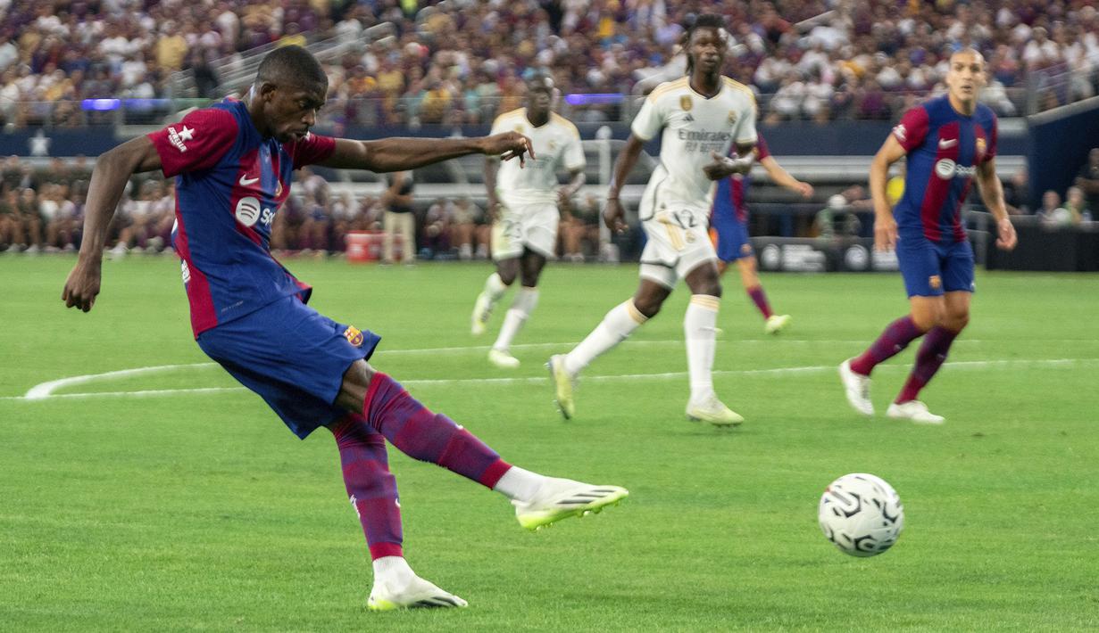 Striker Barcelona, Ousmane Dembele melepaskan tendangan yang menghasilkan gol pertama ke gawang Real Madrid pada laga pramusim Soccer Champions Tour 2023 di AT&T Stadium, Arlington, Texas, Minggu (30/7/2023) dini hari WIB. (AP Photo/Jeffrey McWhorter)