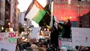 Seorang pengunjuk rasa mengibarkan bendera Palestina saat melakukan protes menentang perang Israel-Hamas bersamaan dengan KTT APEC yang berlangsung di San Francisco, Amerika Serikat, Selasa (14/11/2023). (AP Photo/Godofredo A. Vásquez)