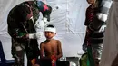 Petugas medis militer mengobati seorang anak laki-laki yang mengalami cedera akibat gempa Lombok di rumah sakit darurat di Kayangan, Rabu (8/8). BPBD Lombok Utara mencatat data sementara jumlah korban jiwa mencapai 347 orang. (AP/Fauzy Chaniago)