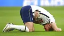 Striker Tottenham Hotspur, Harry Kane, memegang perutnya saat melawan Leicester City pada laga Liga Inggris, Minggu (20/12/2020). Spurs menyerah dengan skor 2-0. (Andy Rain/POOL/AP)