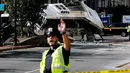 Petugas berjaga di garis polisi di lokasi kejadian tabrakan dua bus di Newark, New Jersey (19/08) waktu setempat. Seorang pengemudi bus New Jersey Transit tewas dan 19 orang dirawat di rumah sakit. (REUTERS/Eduardo Munoz)