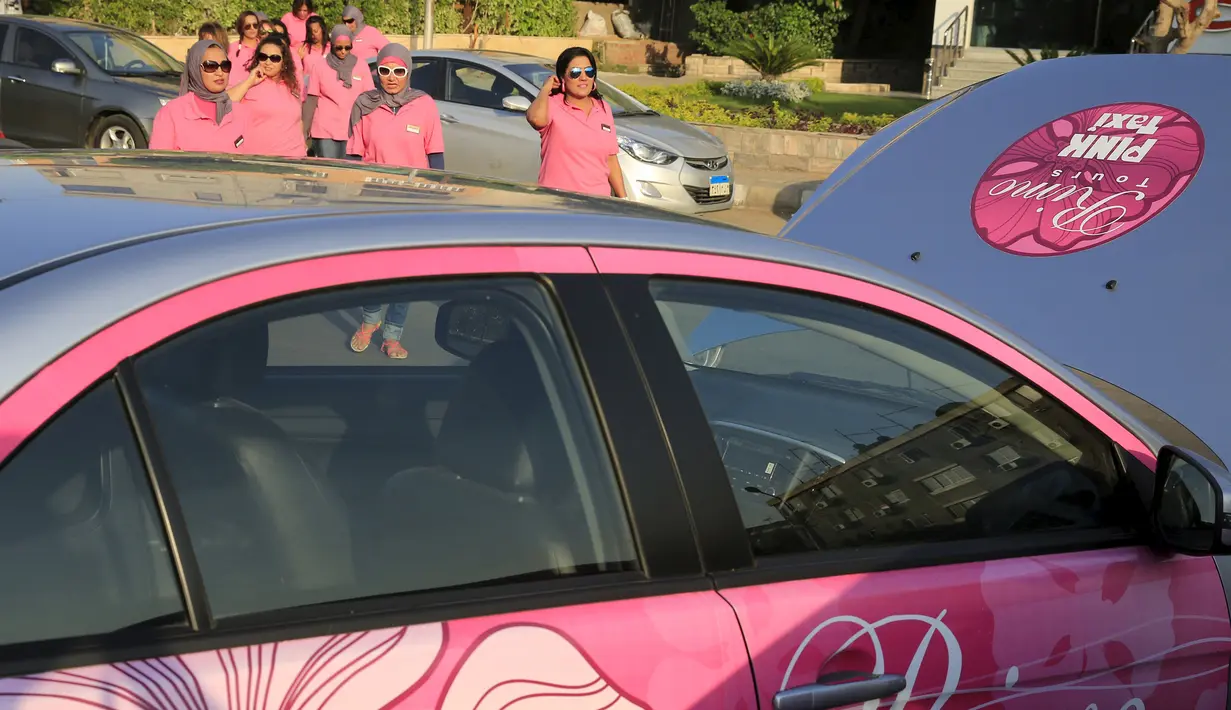 Pengemudi taksi pink berjalan menuju kendaraan mereka di Kairo, Mesir, Selasa (8/9). Pelecehan seksual terhadap kaum perempuan yang kerap terjadi di dalam angkutan umum menjadi alasan khusus berdirinya Pink Taxi. (REUTERS/Amr Abdallah Dalsh)
