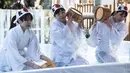 Para wanita penganut Shinto menuangkan air dingin ke tubuh mereka saat melangsungkan ritual ketahanan di Kuil Kanda Myojin, Tokyo, Jepang, Sabtu (26/1). Ritual ini untuk mensucikan jiwa dan raga. (Martin Bureau/AFP)