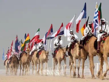 Parade unta dengan bendera saat Kontes Kecantikan Unta di Qatar Camel Mzayen Club, Ash-Shahaniyah, Qatar, 2 Desember 2022. Bersamaan dengan pesta sepak bola Piala Dunia 2022, Qatar juga menggelar Kontes Kecantikan Unta. (AP Photo/Alessandra Tarantino)