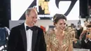 Pangeran William dan Kate Middleton tiba untuk pemutaran perdana premier film James Bond terbaru, No Time To Die, di London, Selasa (28/9/2021). Dress warna gold dengan desain cape dan kerah yang cukup menukik ini membuat pesona Kate Middleton terpancar maksimal. (Chris Jackson/Pool Photo via AP)