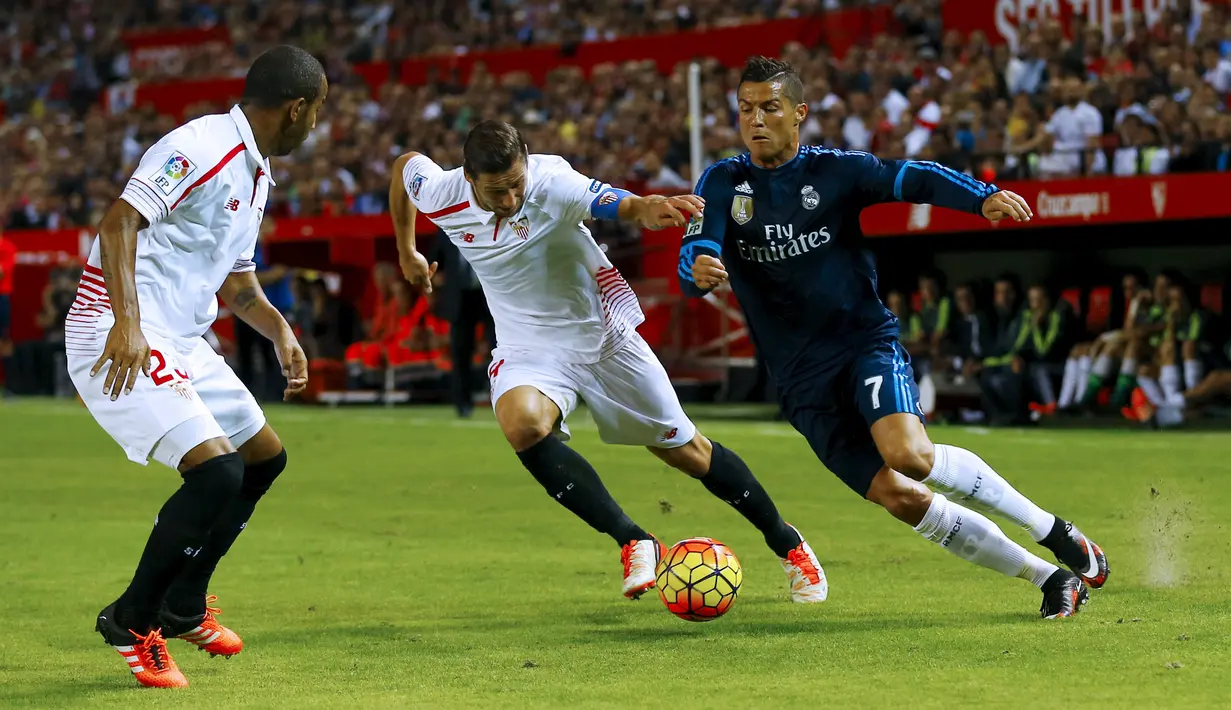 Gelandang Real Madrid, Cristiano Ronaldo (kanan) berusaha melewati dua pemain Sevilla pada lanjutan La Liga di Estadio Ramon Sanchez Pizjuan, Spanyol (9/11/2015). Sevilla menang atas Real Madrid dengan skor 3-2. (REUTERS/Marcelo del Pozo)