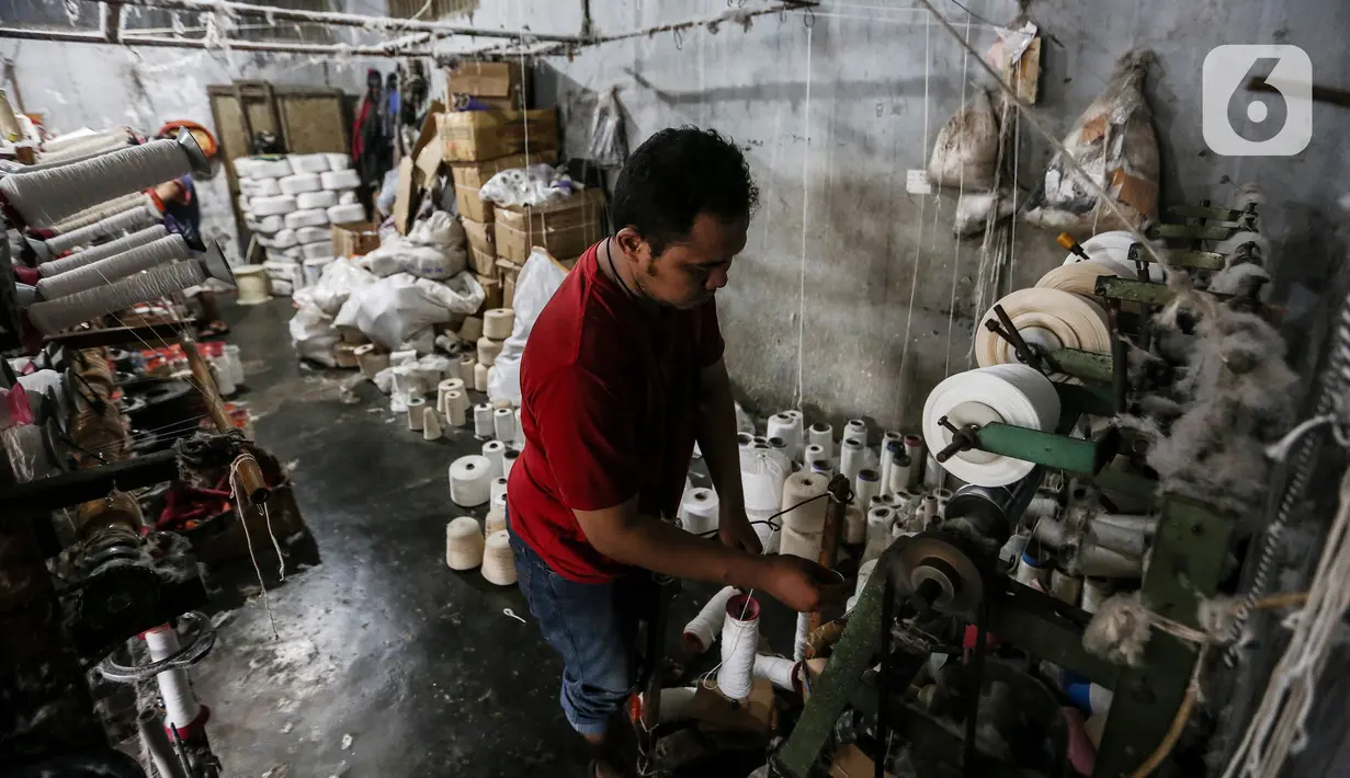 Pekerja memintal benang di Kebayoran, Jakarta, Selasa (5/7/2022). Pabrik benang yang berdiri sejak tahun 1970-an tersebut dapat memproduksi 100 kilogram benang dalam sehari dan dipasarkan ke berbagai daerah di Indonesia. (Liputan6.com/Johan Tallo)