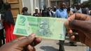 Seorang pria memegang salah satu uang kertas baru yang dikeluarkan Reserve Bank of Zimbabwe di Harare, 12 November 2019. Pemerintah Zimbabwe memperkenalkan kembali mata uang negaranya setelah hampir satu dekade terakhir menggunakan mata uang negara lain untuk bertransaksi. (AP/Tsvangirayi Mukwazhi)