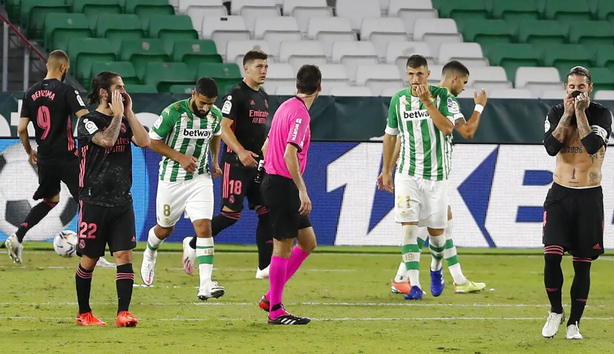 Pemain Real Madrid Sergio Ramos (kanan) bereaksi saat menghadapi pada pertandingan La Liga di Stadion Benito Villamarin, Seville, Spanyol, Sabtu (26/9/2020). Real Madrid mengalahkan Real Betis 3-2. (AP Photo/Angel Fernandez)