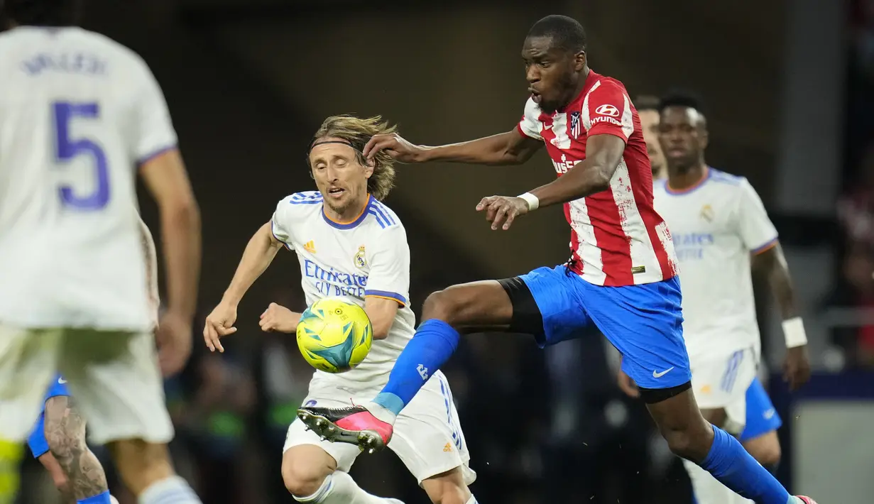 <p>Gelandang Real Madrid Luka Modric berebut bola dengan gelandang Atletico Madrid Geoffrey Kondogbia dalam laga pekan ke-35 Liga Spanyol di Wanda Metropolitano, Senin (9/5/2022) dini hari WIB. Atletico Madrid berhasil menang dengan skor tipis 1-0 atas Real Madrid. (AP Photo/Manu Fernandez)</p>