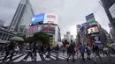 Orang-orang mengenakan masker untuk mencegah virus corona berjalan melintasi penyeberangan pejalan kaki pada awal liburan "Minggu Emas" Jepang di distrik Shibuya, Tokyo, Kamis (29/4/2021). Pemerintah Jepang meminta warga untuk tinggal di rumah selama "minggu emas". (AP Photo/Eugene Hoshiko)