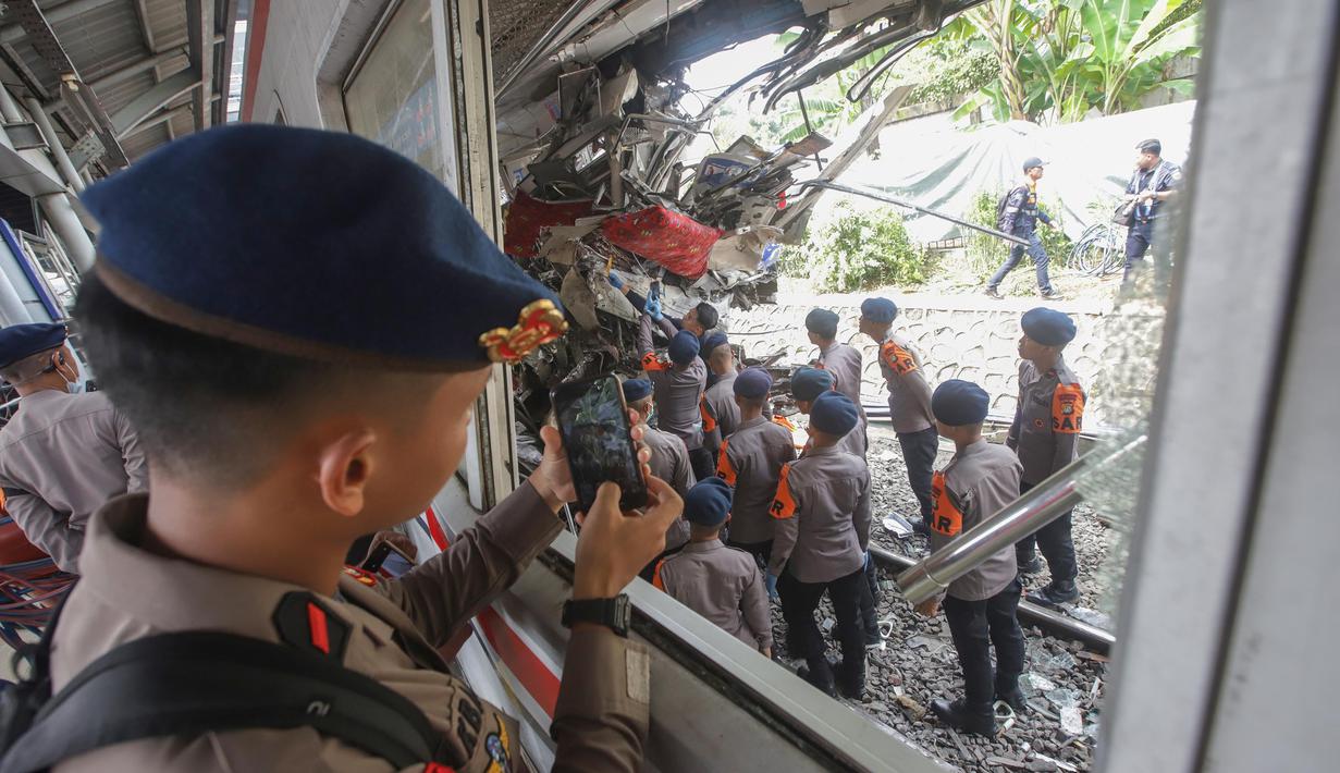 Personel kepolisian mengabadikan proses evakuasi gerbong Kereta Rel Listrik (KRL) Commuter Line pasca-tabrakan Kereta Api Jarak Jauh (KAJJ) Argo Bromo Anggrek relasi Gambir-Surabaya Pasar Turi di Stasiun Bekasi Timur, Bekasi, Jawa Barat, Selasa (28/4/2026). (merdeka.com/Arie Basuki)