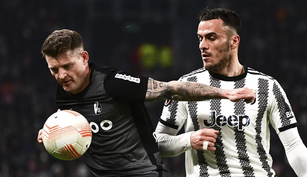 Bek Freiburg, Lukas Kubler berebut bola dengan gelandang Juventus, Filip Kostic dalam laga leg pertama babak 16 besar Liga Europa 2022-2023 di Allianz Stadium, Jumat (10/3/2023) dini hari WIB. Freiburg jelas membuat Juve kesulitan di pertandingan kali ini. (Marco Alpozzi/LaPresse via AP)