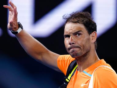 Petenis Spanyol Rafael Nadal melambaikan tangan saat meninggalkan Rod Laver Arena menyusul kekalahannya atas petenis Amerika Serikat Mackenzie McDonald pada putaran kedua kejuaraan tenis Australian Open di Melbourne, Australia, Rabu (18/1/2023). Rafael Nadal harus tersingkir dari Australian Open 2023 setelah ia mengalami cedera dan kemudian takluk 4-6, 4-6, 5-7 dari petenis Amerika Serikat MacKenzie McDonald. (AP Photo/Asanka Brendon Ratnayake)