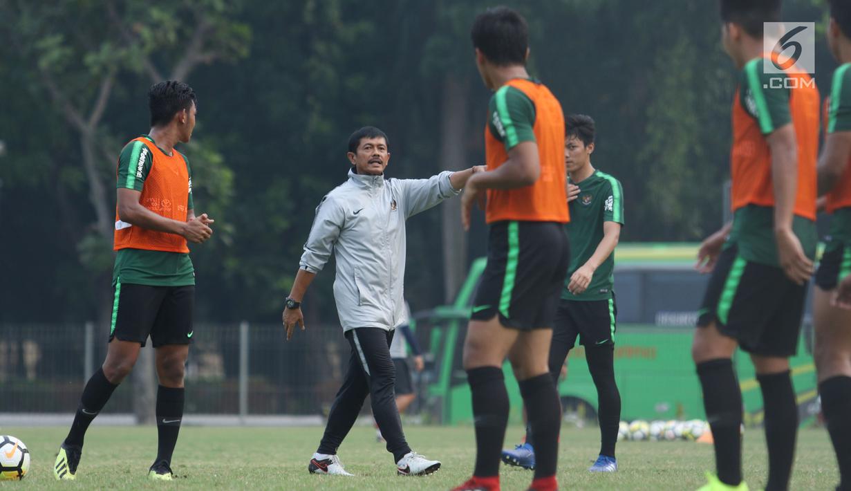 Pelatih Timnas Indonesia U-19, Indra Sjafri (jaket putih) memberi arahan pada timnya saat latihan jelang laga perdana Grup A Piala AFC U-19 melawan Chinese Taipei di Lapangan A Kompleks GBK, Jakarta, Rabu (17/10). (Liputan6.com/Helmi Fithriansyah)
