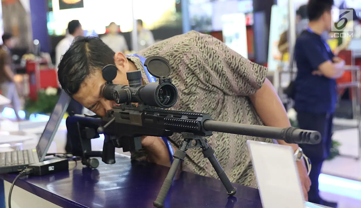 Seorang pengunjung mencoba senjata laras panjang yang dipajang dalam pameran Indo Security 2017 di JCC, Jakarta, Rabu (12/7). Pameran ini diikuti 670 peserta dari 35 negara yang menampilkan produk dan teknologi mutakhir. (Liputan6.com/Angga Yuniar)