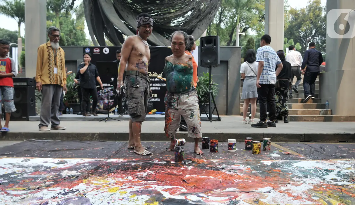 Sadikin Pard (53) membuat karya lukisan dengan kedua kakinya saat Indonesian Art Festival di Museum Nasional, Jakarta, Minggu (10/11/2019). Sadikin  merupakan salah satu anggota Association of Mouth an Foot Painting Artist (AMFPA), sebuah organisasi di Swiss. (merdeka.com/Iqbal S. Nugroho)