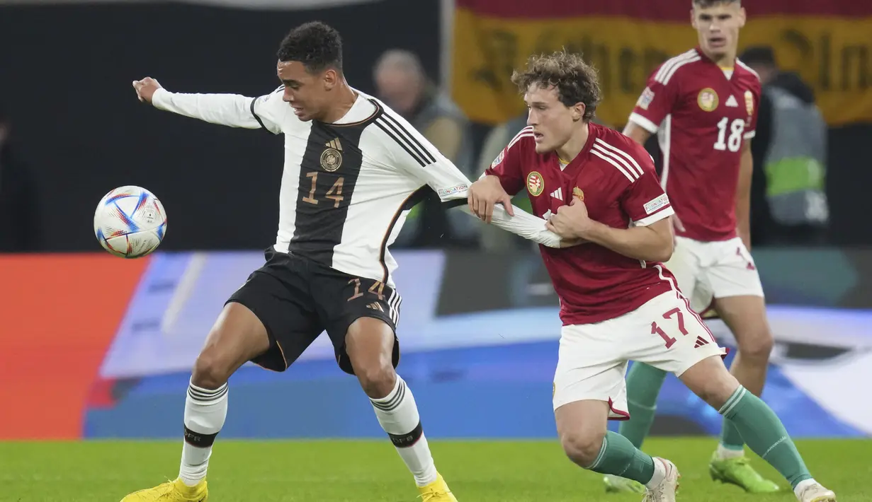 Pemain Hungaria, Callum Styles berusaha merebut bola dari pemain Jerman, Jamal Musala selama pertandingan UEFA Nations League di Red Bull Arena di Leipzig, Jerman, Jumat, 23 September 2022. Hungaria bertahan di puncak dengan 10 poin, unggul dua poin dari Italia yang baru saja mengalahkan Inggris 1-0. (AP Photo/Michael Sohn)