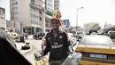 Seorang pedagang kaki lima membawa dagangannya di Dakar (4/2/2022). Senegal akan bertanding melawan Mesir pada babak final Piala Afrika 2021 di Paul Biya stadium, Senin (7/2/2022) dini hari WIB besok. (AFP/Seyllou)