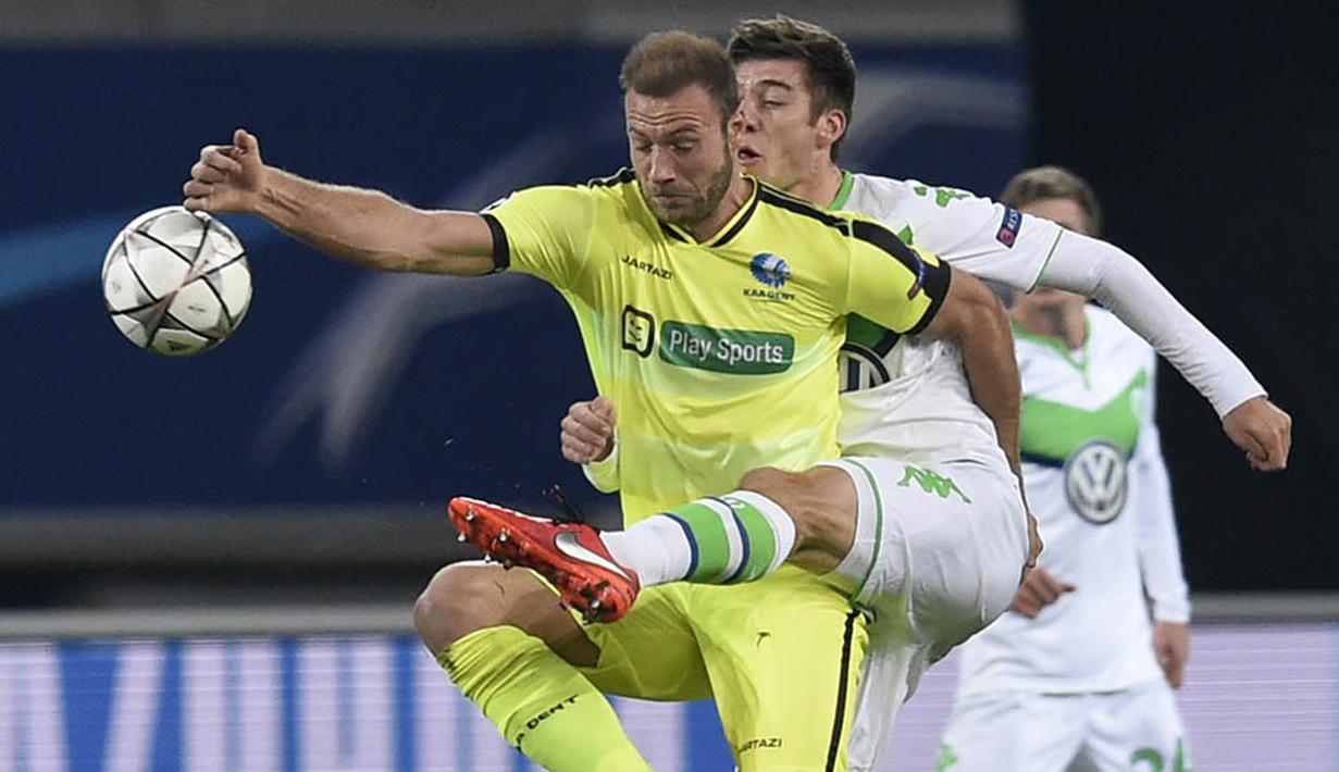 Striker Gent, Laurent Depoitre, berebut bola dengan bek Wolfsburg, Robin Knoche. Sementara Gent baru bisa mengecilkan keadaan melalui du gol di menit ke 80 dan 89. (AFP/John Thys)