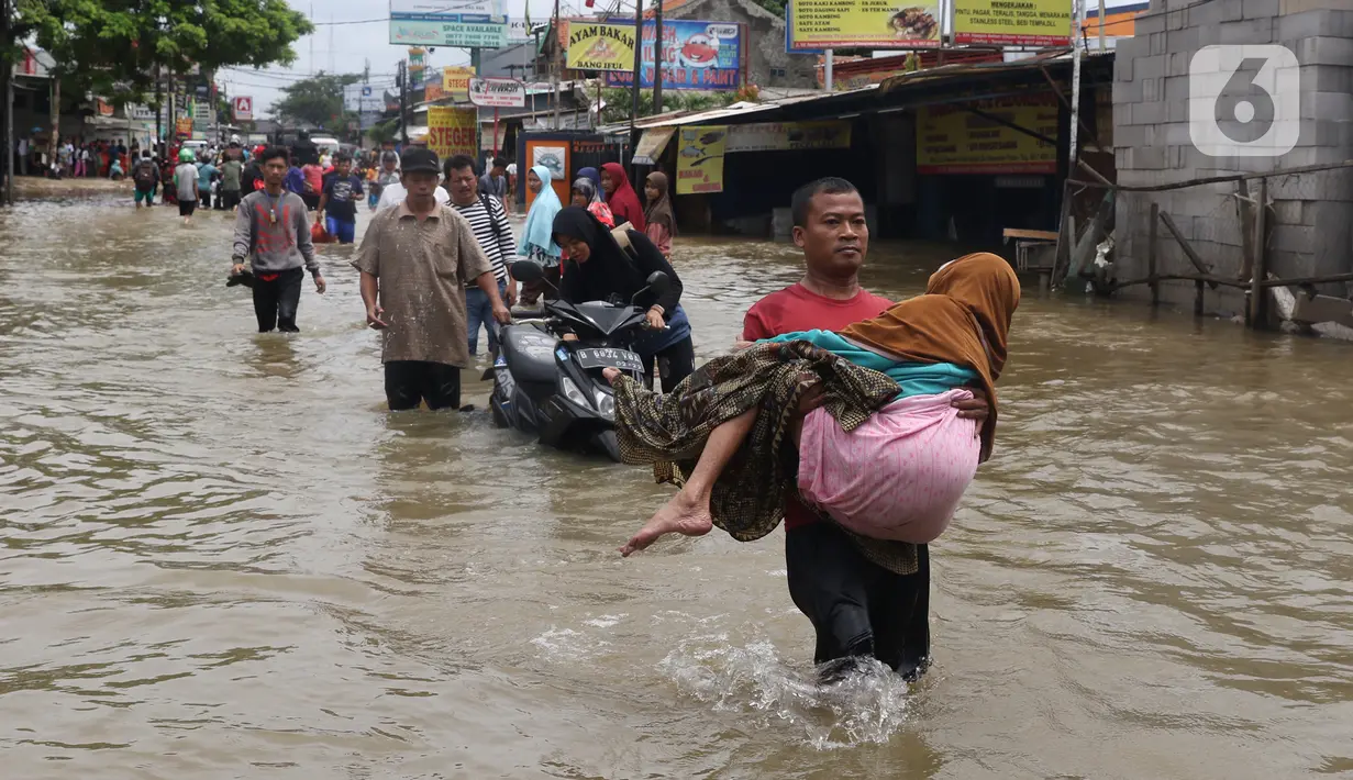 Seorang nenek digendong saat melintasi banjir yang menggenangi Jalan KH Hasyim Ashari, Tangerang, Banten, Kamis (2/1/2020). Banjir yang menggenangi jalan penghubung Jakarta- Tangerang tersebut mulai surut dan sudah bisa dilintasi pejalan kaki. (Liputan6.com/Angga Yuniar)
