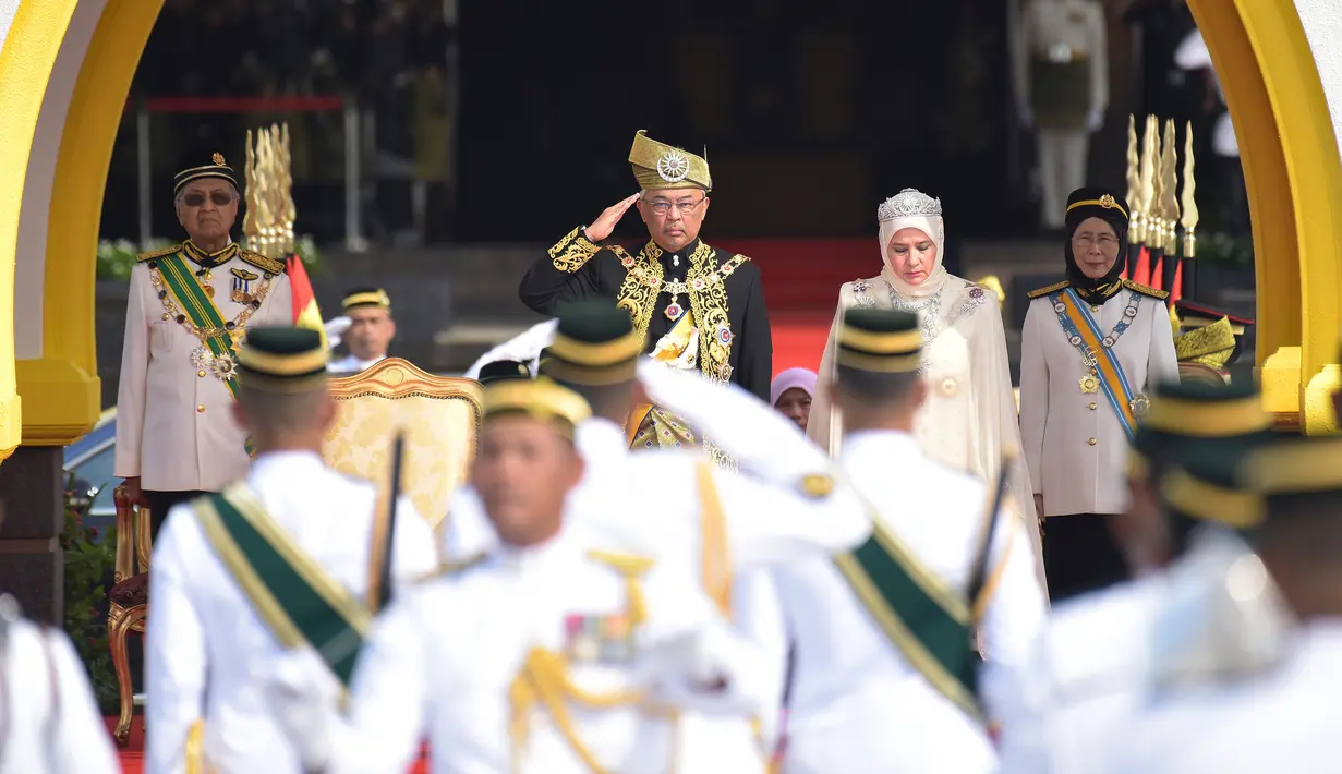 Raja Malaysia Abdullah Ri'ayatuddin Al-Mustafa Billah Shah (dua kiri) didampingi Ratu Tunku Hajah Azizah, PM Malaysia Mahathir Mohamad dan wakilnya Wan Azizah memberi hormat kepada penjaga kerajaan saat penobatan kerajaan di Kuala Lumpur, Selasa (30/7/2019). (Malaysia Information Ministry via AP)