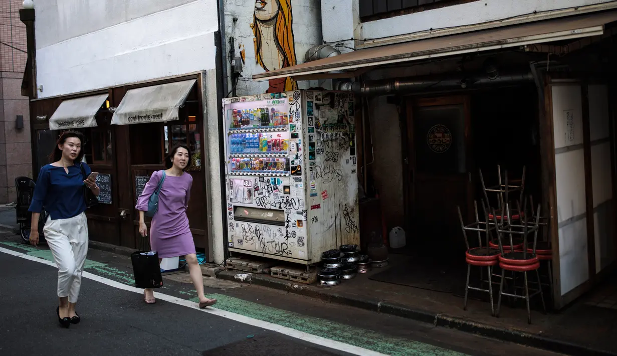 Dua wanita berjalan di sebuah gang di lingkungan Shibuya di Tokyo, Jepang (23/5/2019). Pada tahun 2008, distrik kota ini mempunyai populasi sekitar 208.371 jiwa dan kepadatan penduduk 13.337,13 orang per km². (AFP Photo/Behrouz Mehri)