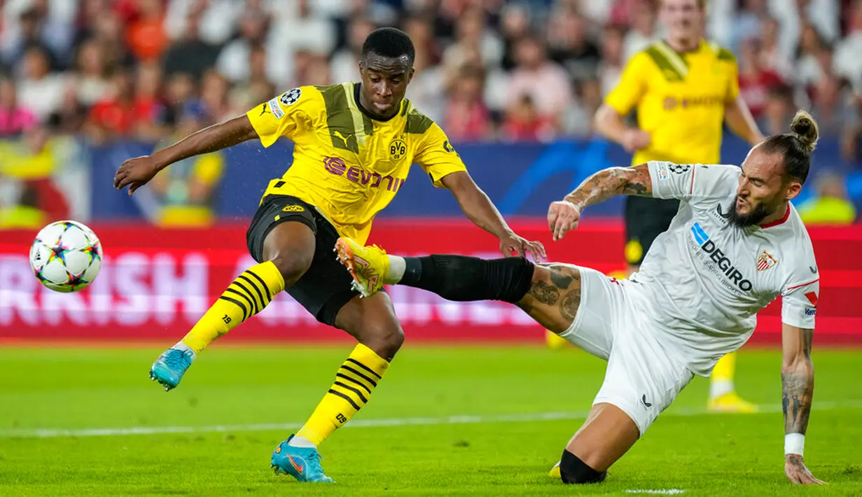 Pemain Sevilla Nemanja Gudelj (kanan) berebut bola dengan pemain Borussia Dortmund Youssoufa Moukoko pada pertandingan Grup G Liga Champions di Stadion Ramon Sanchez Pizjuan, Seville, Spanyol, 5 Oktober 2022. Borussia Dortmund menang 4-1. (AP Photo/Jose Breton)