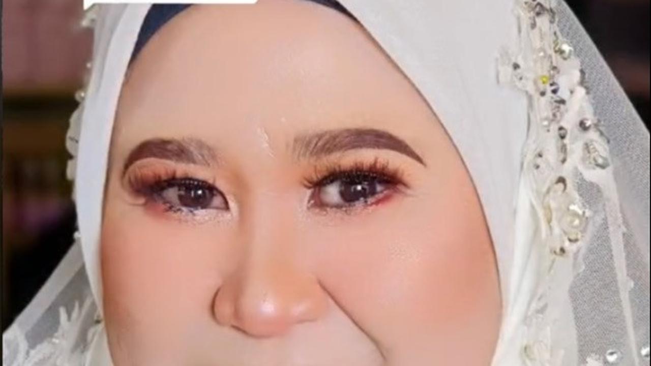 Emak-emak ini dengan cantik memakai gaun pengantin warna putih. Bagian hijabnya dihiasi crown untuk mempercantik. Penampilannya ini disebut lebih muda 20 tahun.