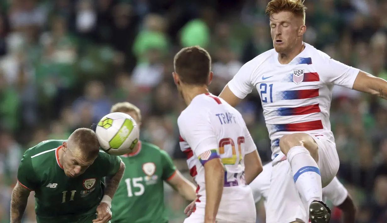 Aksi pemain Irlandia, James McClean menyundul bola melewati adangan para pemain Amerika serikat pada laga uji coba di Aviva Stadium, Dublin, (2/6/2018). Irlandia menang 2-1. (Brian Lawless/PA via AP)