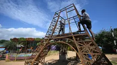 Para pekerja membangun model replika Menara Eiffel di sebuah taman di Puducherry, sebuah wilayah bekas koloni Prancis di India pada tanggal 18 Januari 2024. (Arun SANKAR/AFP)