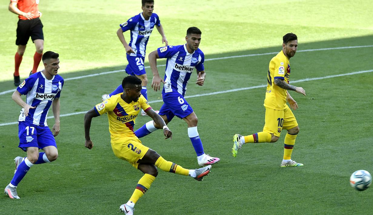 Pemain Barcelona, Nelson Semedo, melepaskan tendangan ke gawang Alaves pada laga La Liga di Stadion Mendizorroza, Minggu (19/7/2020). Barcelona menang dengan skor 5-0. (AP/Alvaro Barrientos)