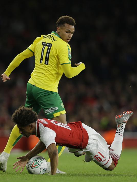 Pemain Arsenal, Reiss Nelson (bawah) terjatuh saat berebut bola dengan pemain Norwich City, Josh Murphy pada laga Piala Liga Inggris di Emirates Stadium, London, (24/10/2017). Arsenal menang 2-1. (AP/Alastair Grant)