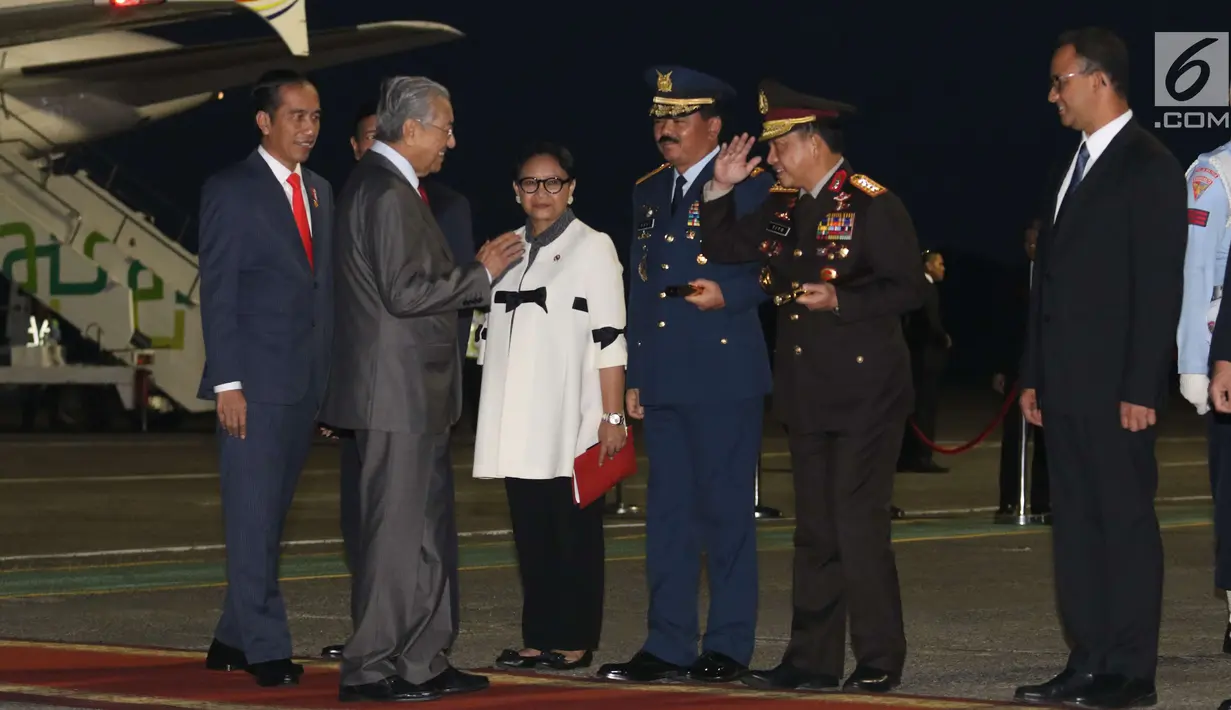 PM Malaysia Mahathir Mohamad menyapa Panglima TNI Marsekal Hadi Tjahjanto dan Kapolri Jenderal Pol Tito Karnavian saat tiba di Bandara Halim Perdanakusuma, Jakarta, Kamis (28/6). (Liputan6.com/Angga Yuniar)